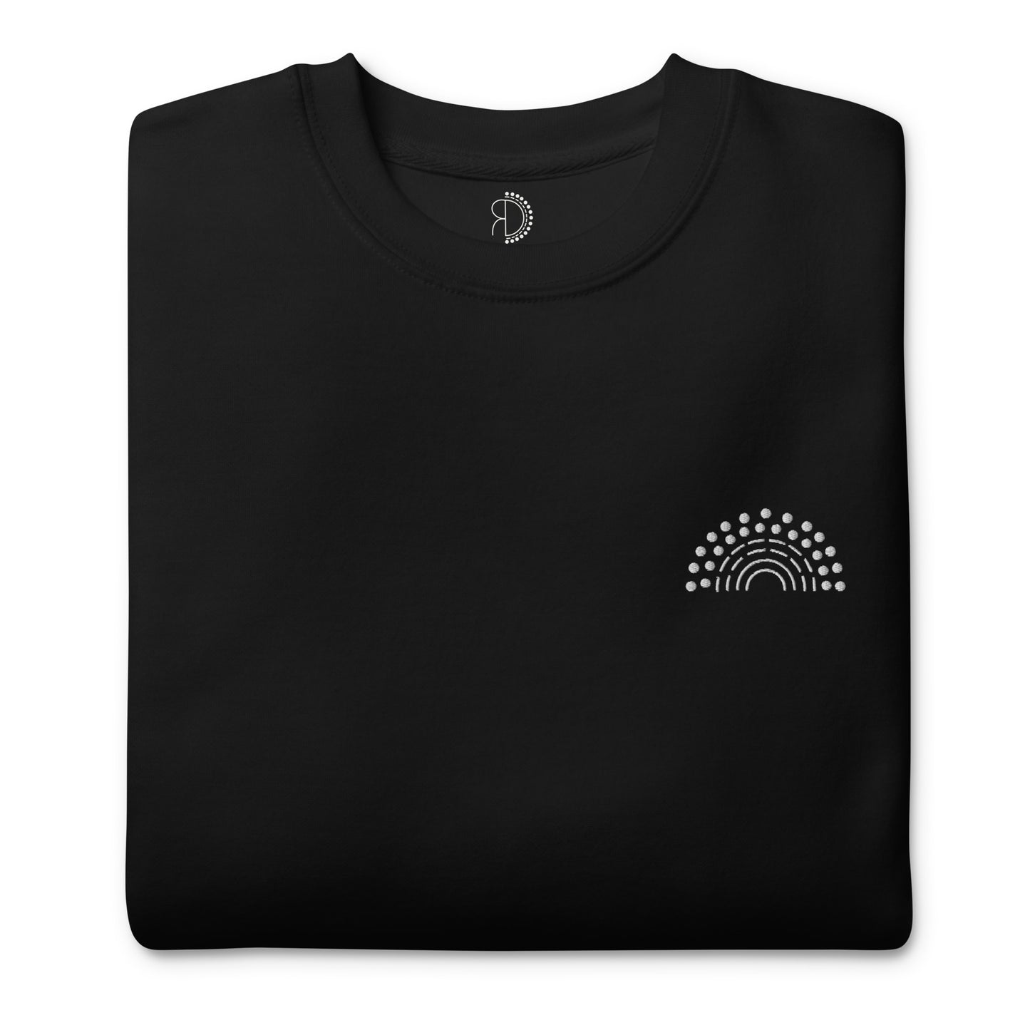 folded black crewneck sweatshirt with white pride rainbow embroidered on the left chest