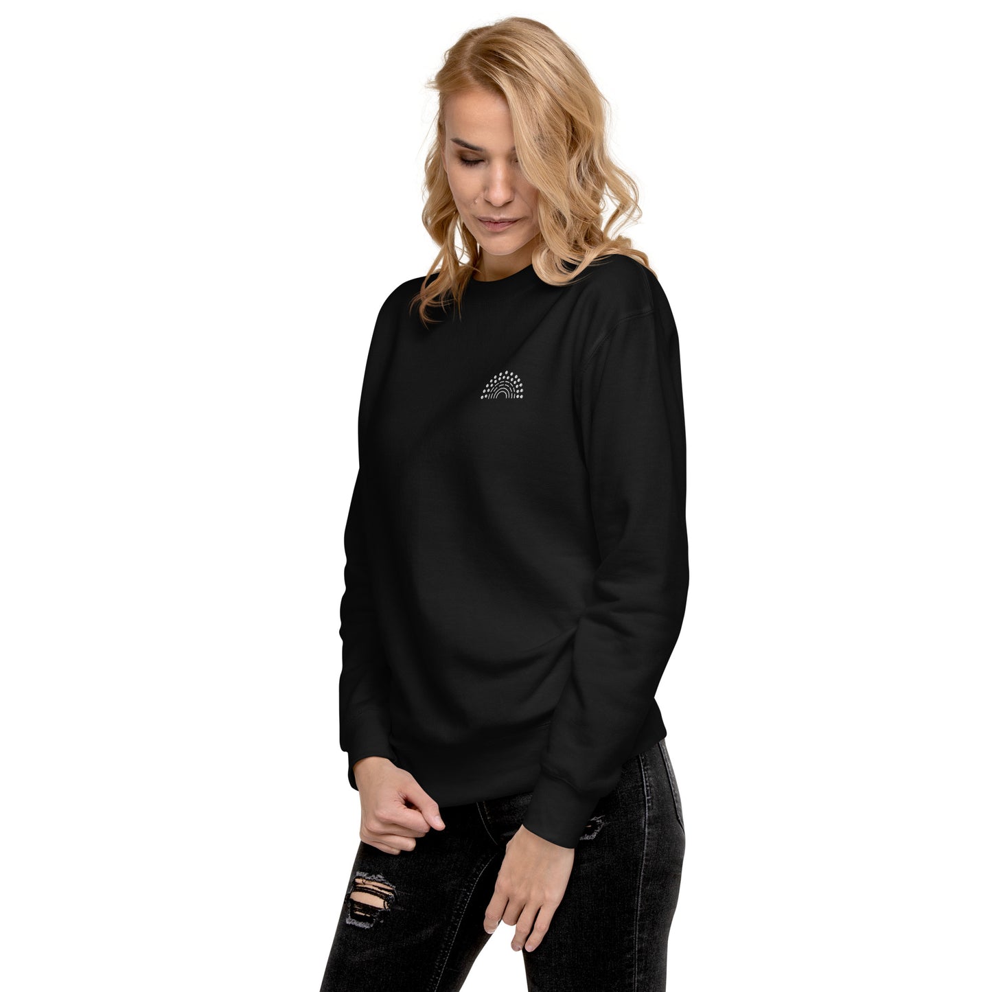 person wearing a black crewneck sweatshirt with white pride rainbow embroidered on the left chest