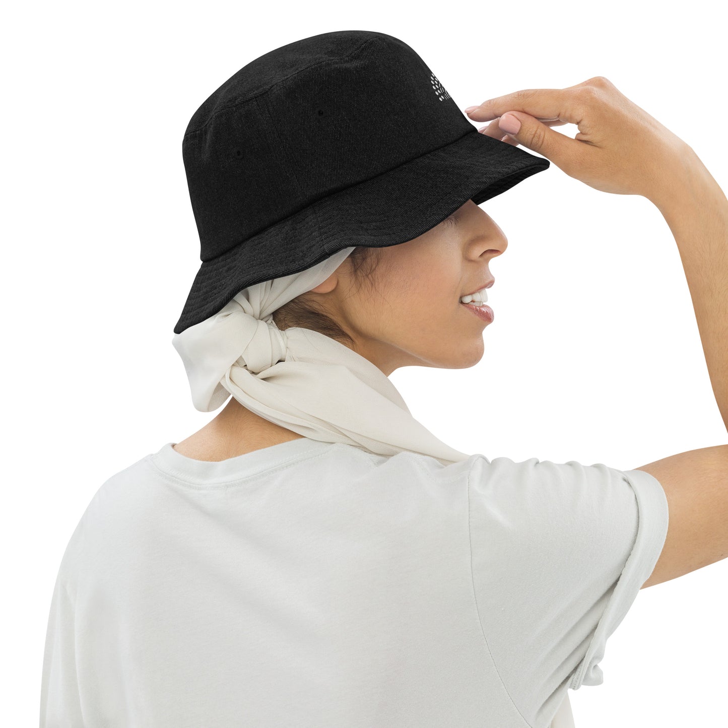 person wearing a black denim bucket hat with white pride rainbow embroidered on center of the hat