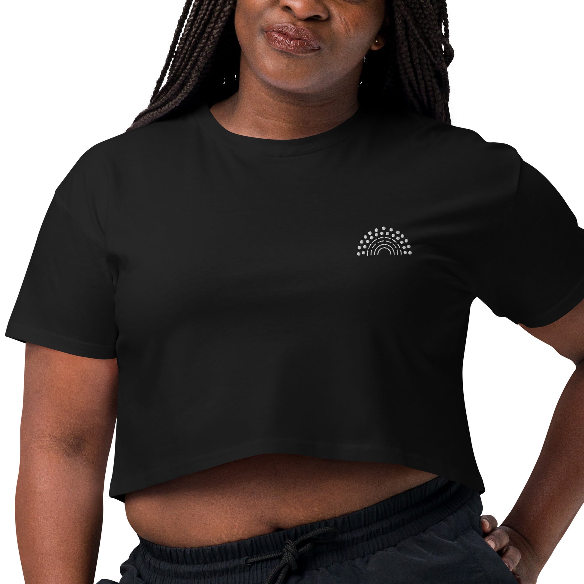 zoomed in image of person wearing a black crop top with white pride rainbow embroidered on the left chest