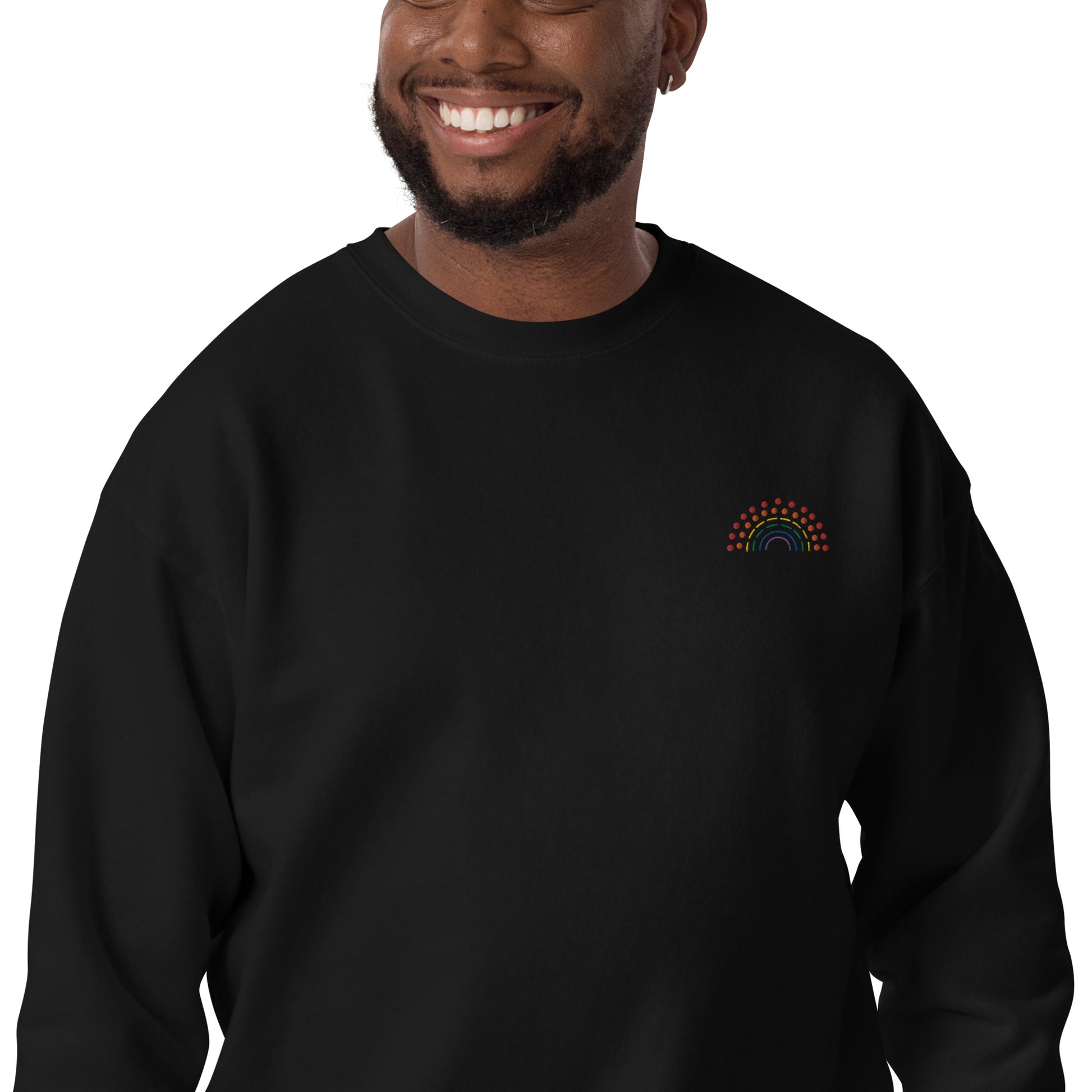 zoomed in image of person wearing a black crewneck sweatshirt with multicolored pride rainbow embroidered on the left chest