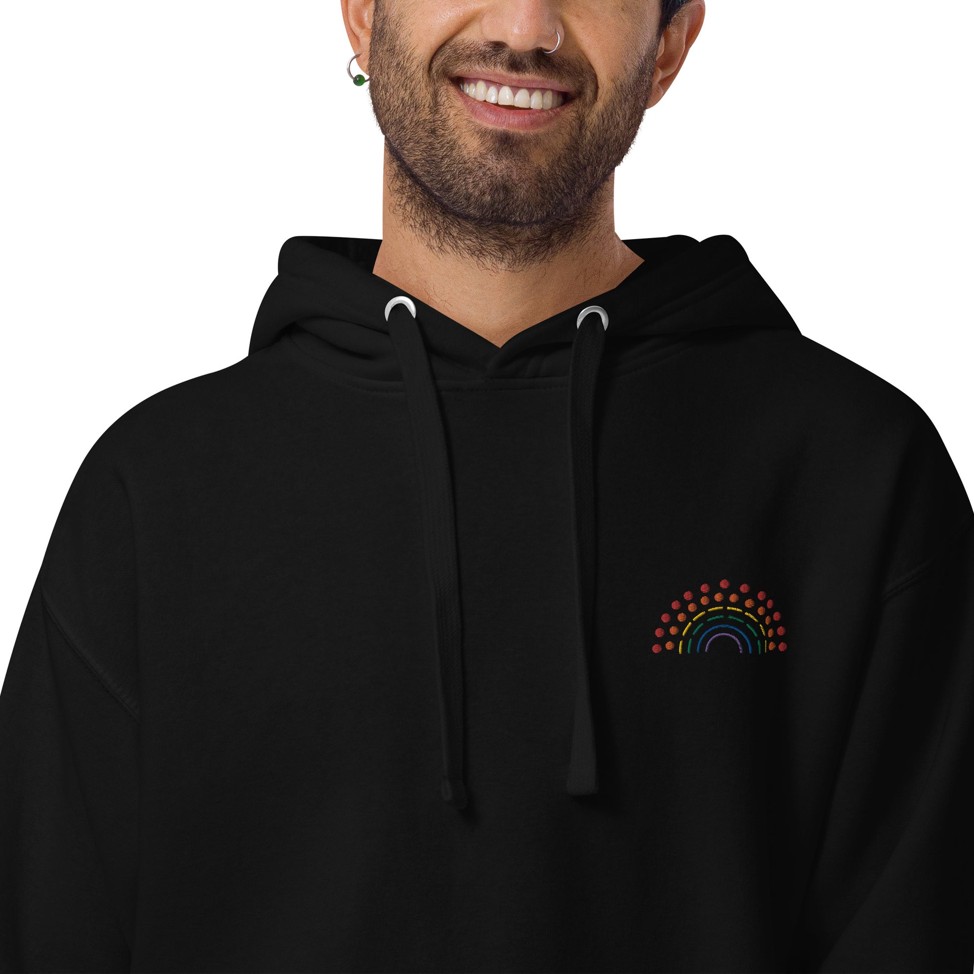 person wearing a black hoodie sweatshirt with multicolored pride rainbow embroidered on the left chest