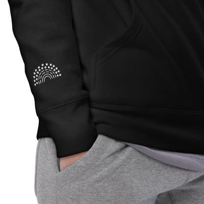 zoomed in image of person wearing a black hoodie sweatshirt with white pride rainbow embroidered on the right wrist