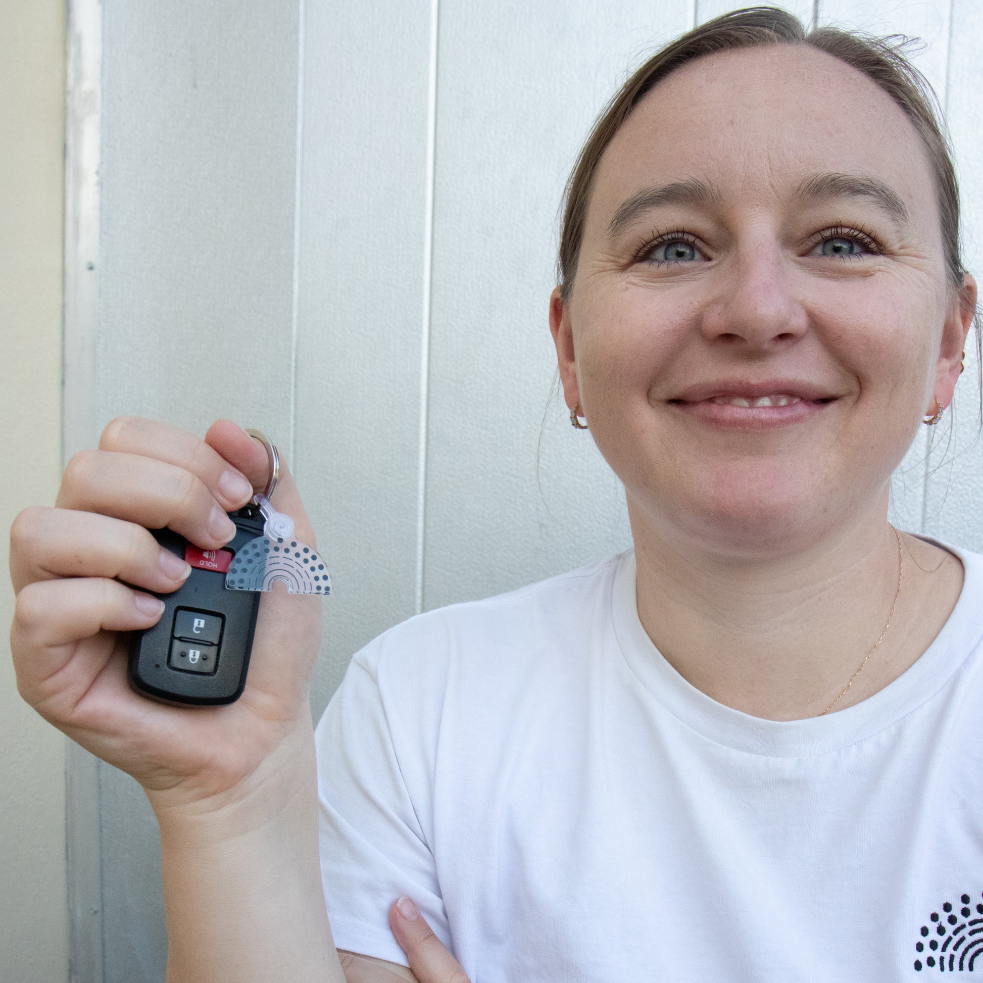 Person holding car keys with black and white pride keychain