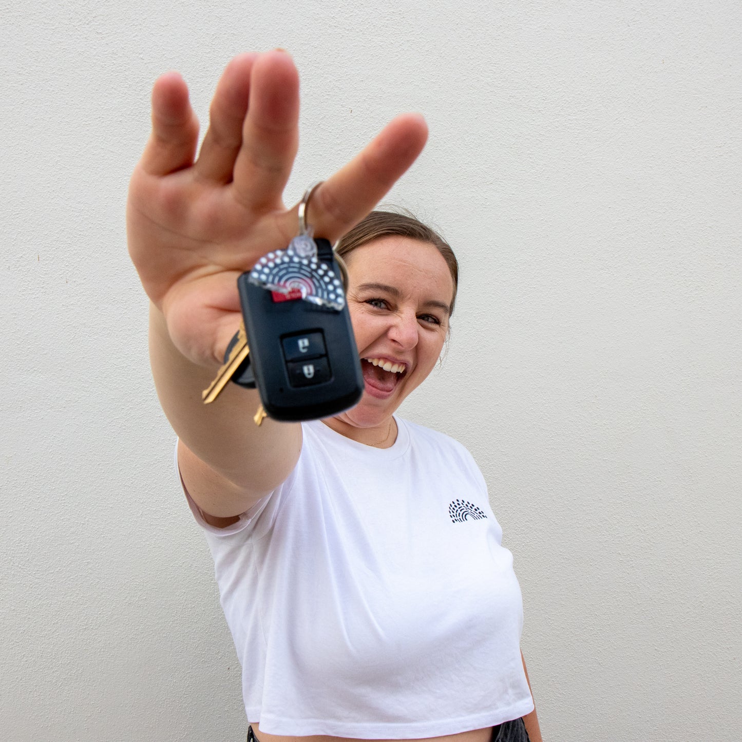 Person holding car keys with black and white pride keychain