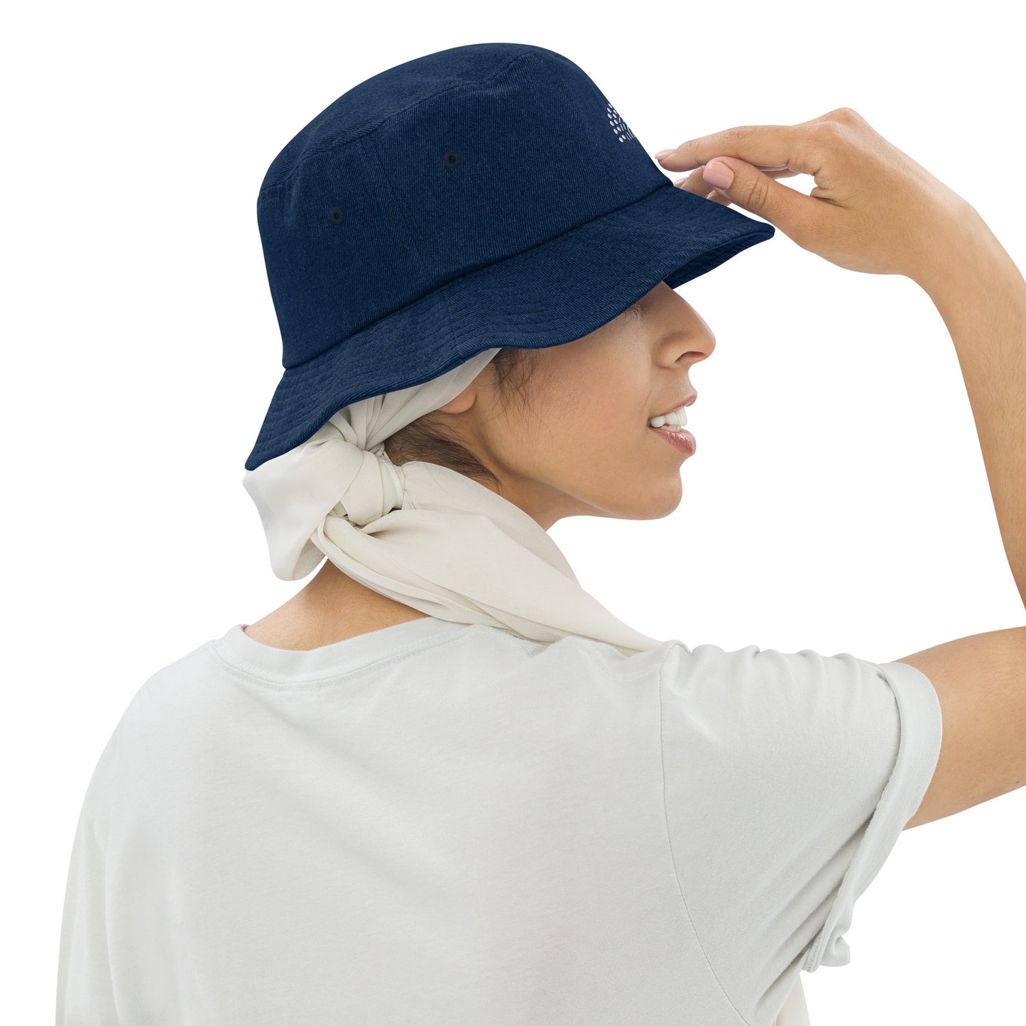 person wearing a dark blue denim bucket hat with white pride rainbow embroidered on center of the hat