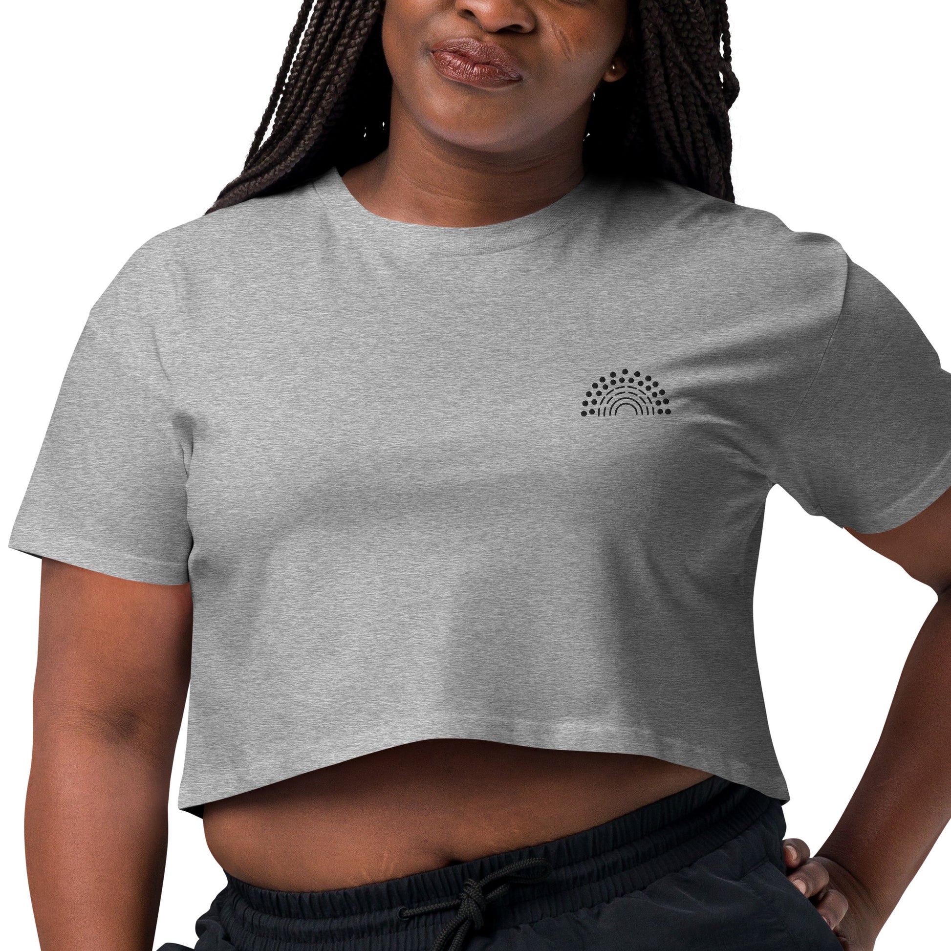 zoomed in image of person wearing a grey crop top with black pride rainbow embroidered on the left chest