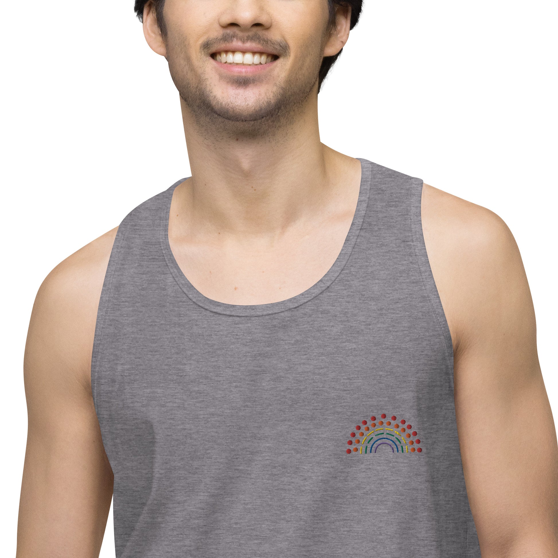 zoomed in image of person wearing a grey athletic tank top with multicolored pride rainbow embroidered on the left chest