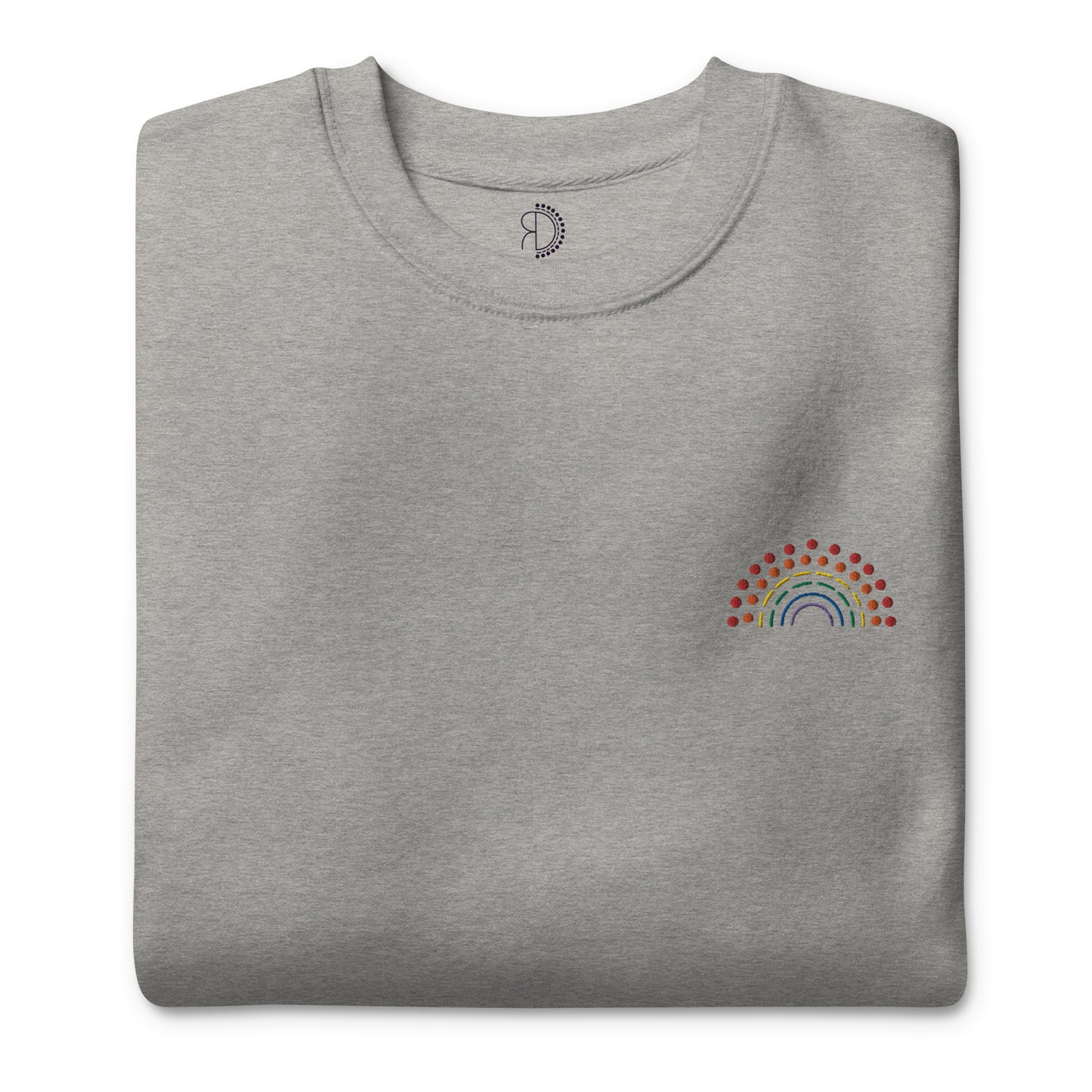 folded grey crewneck sweatshirt with multicolored pride rainbow embroidered on the left chest and an inside label featuring logo