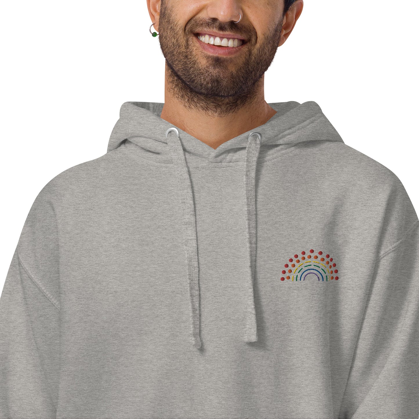 person wearing a grey hoodie sweatshirt with multicolored pride rainbow embroidered on the left chest