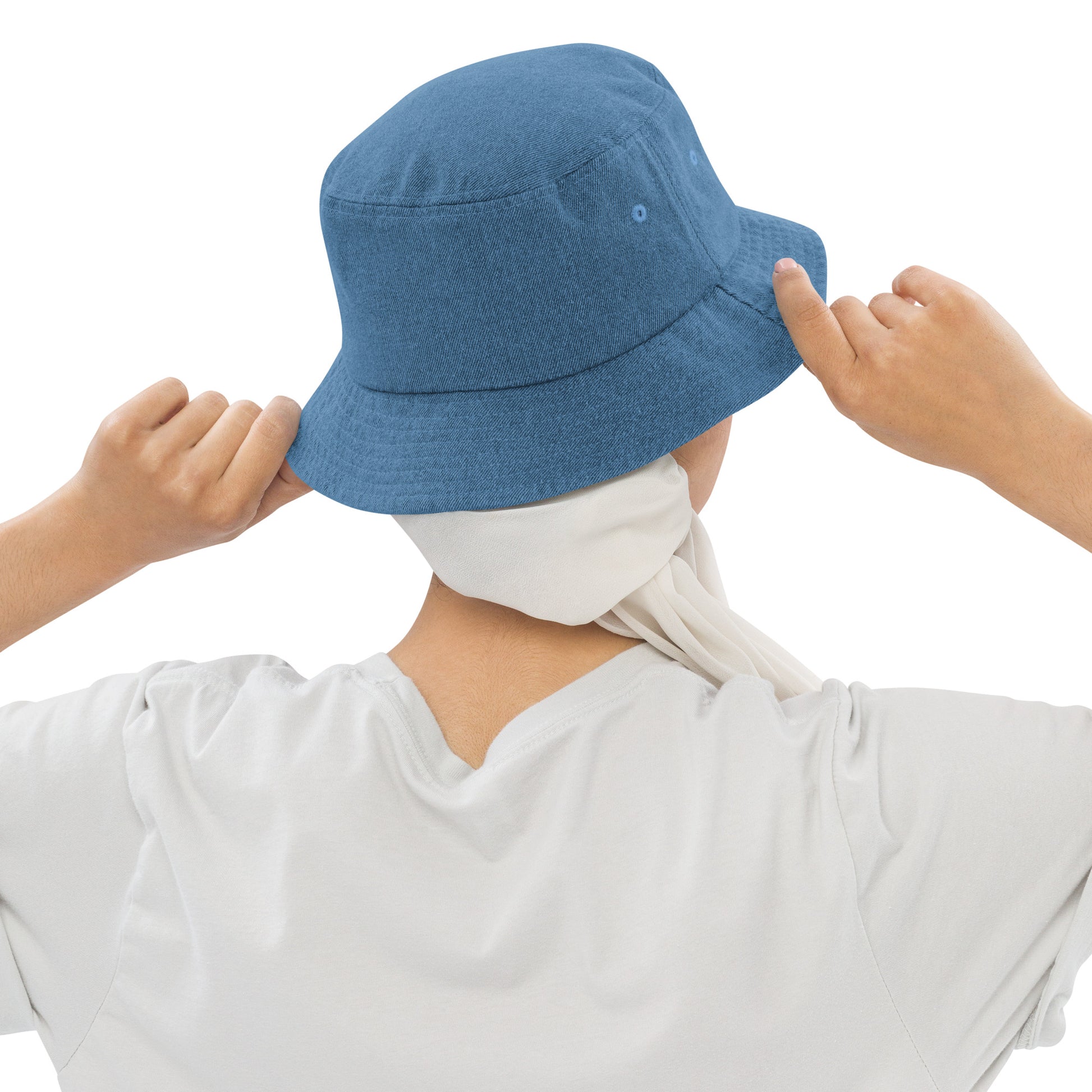 person wearing a light blue denim bucket hat displaying the back of the hat