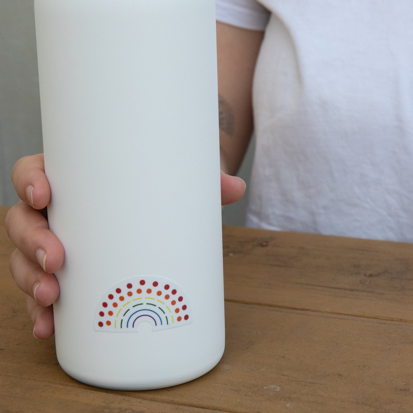 Zoomed in image of a water bottle with a multicolored pride sticker 