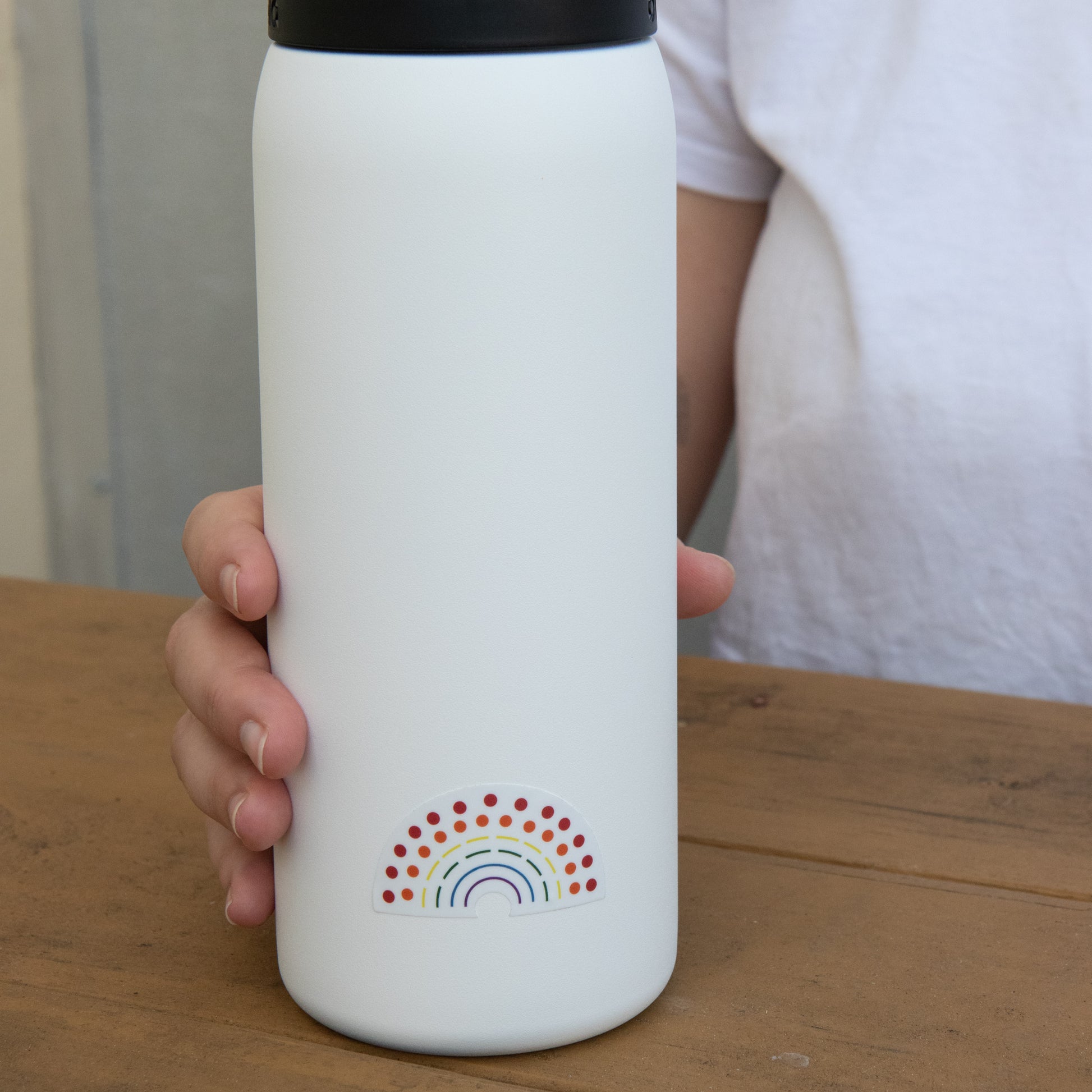 Zoomed in image of a water bottle with a multicolored pride sticker 