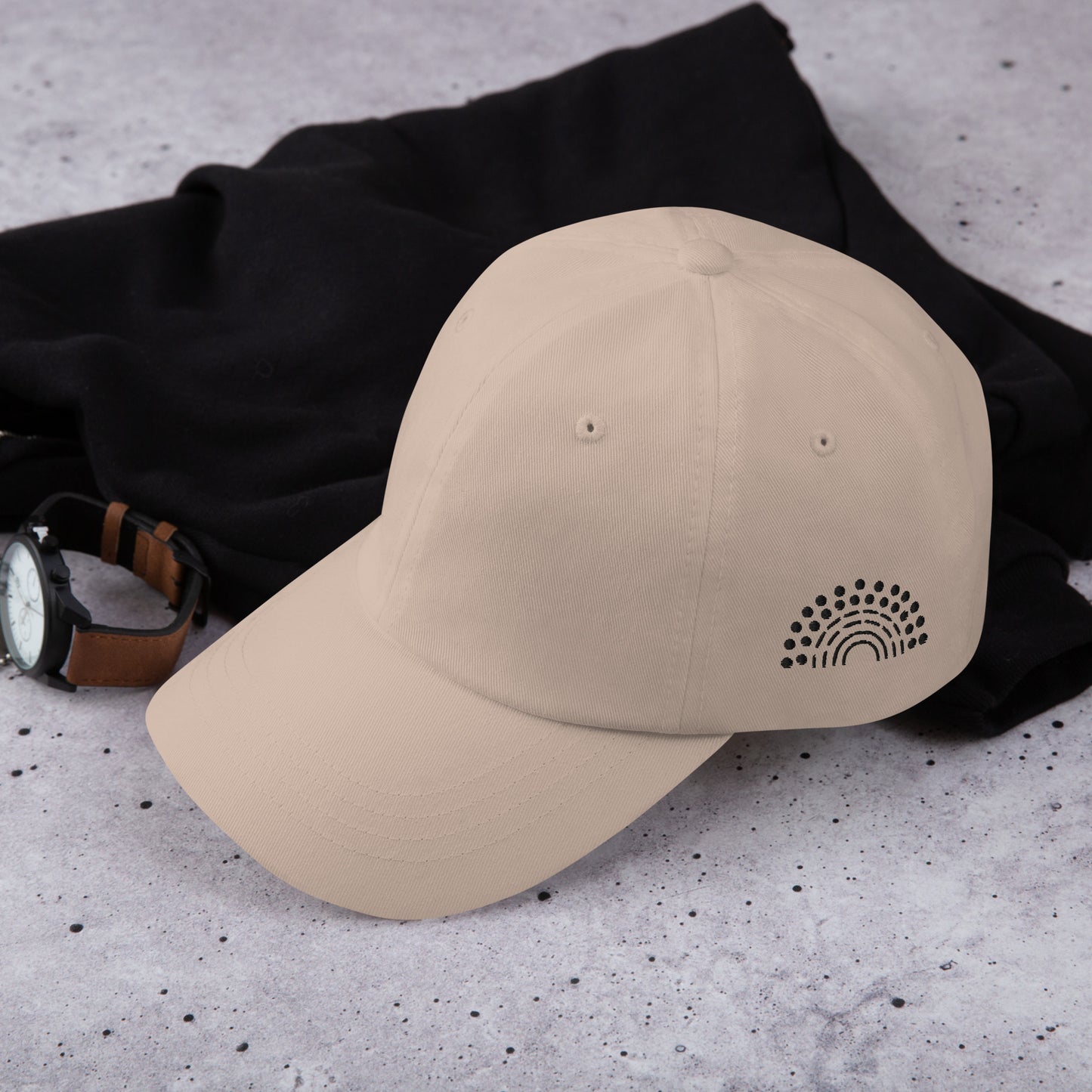 stone tan baseball dad hat with black pride rainbow embroidered on the left of the hat amongst other clothing items