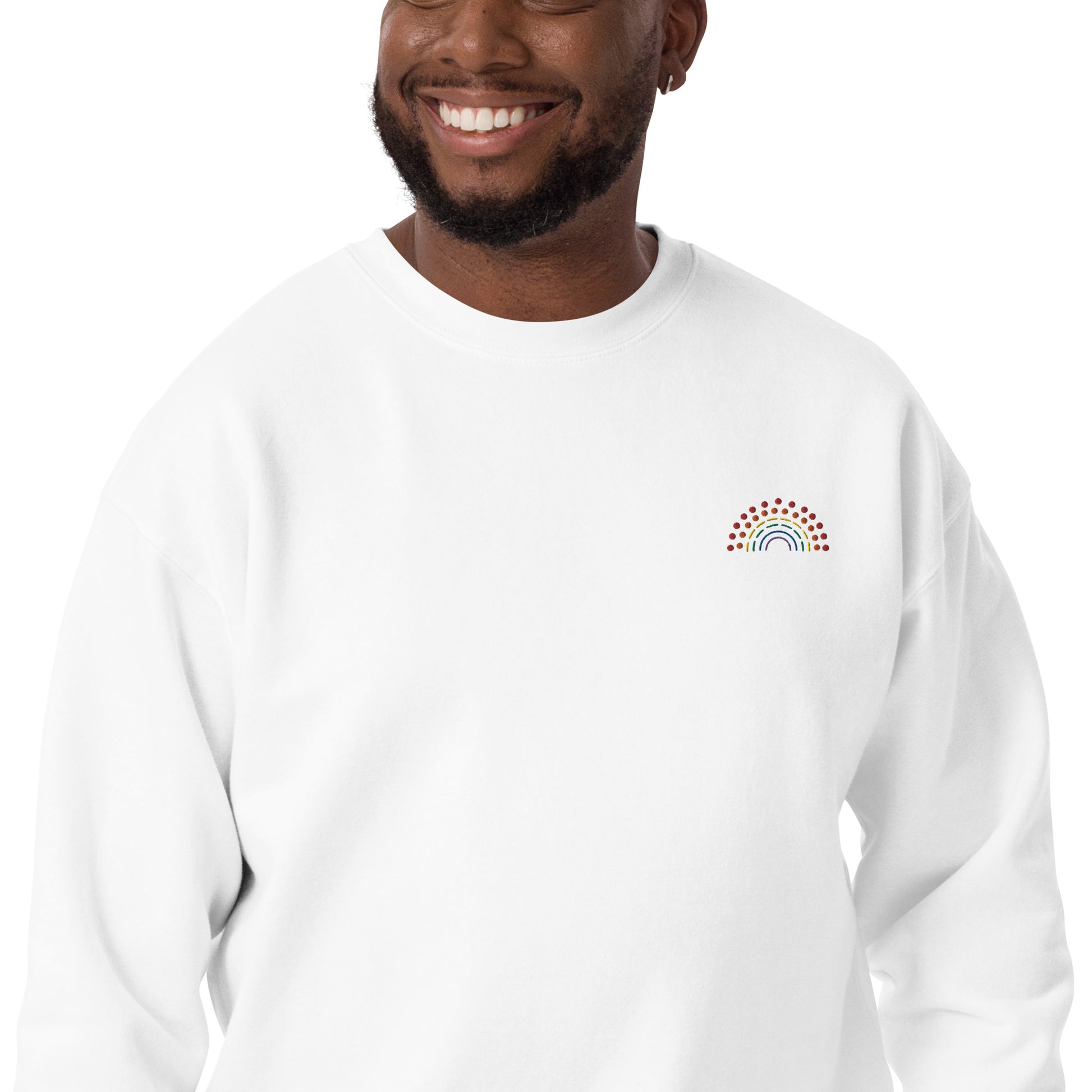 zoomed in image of person wearing a white crewneck sweatshirt with multicolored pride rainbow embroidered on the left chest