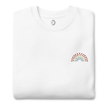 folded white crewneck sweatshirt with multicolored pride rainbow embroidered on the left chest and an inside label featuring logo