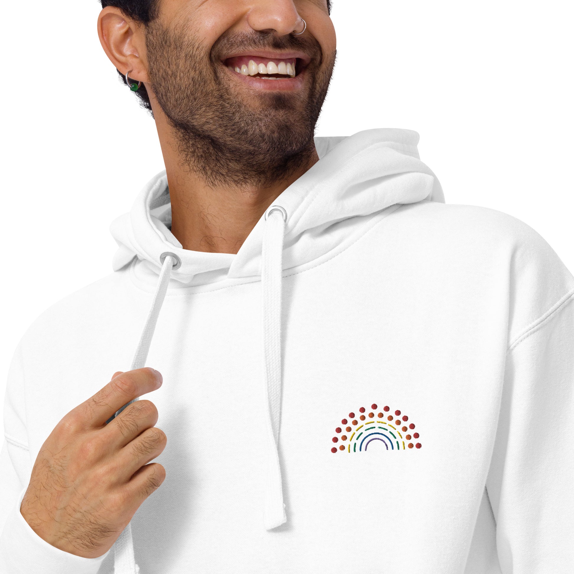 zoomed in image of person wearing a white hoodie sweatshirt with multicolored pride rainbow embroidered on the left chest